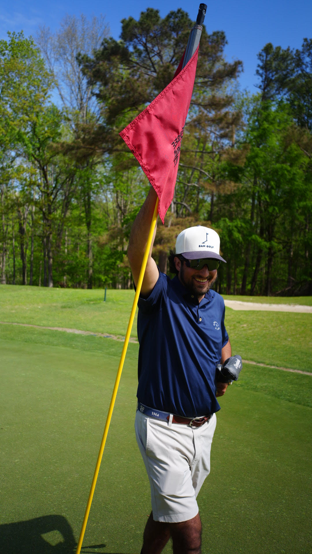 Noah on the golf course holding a flag